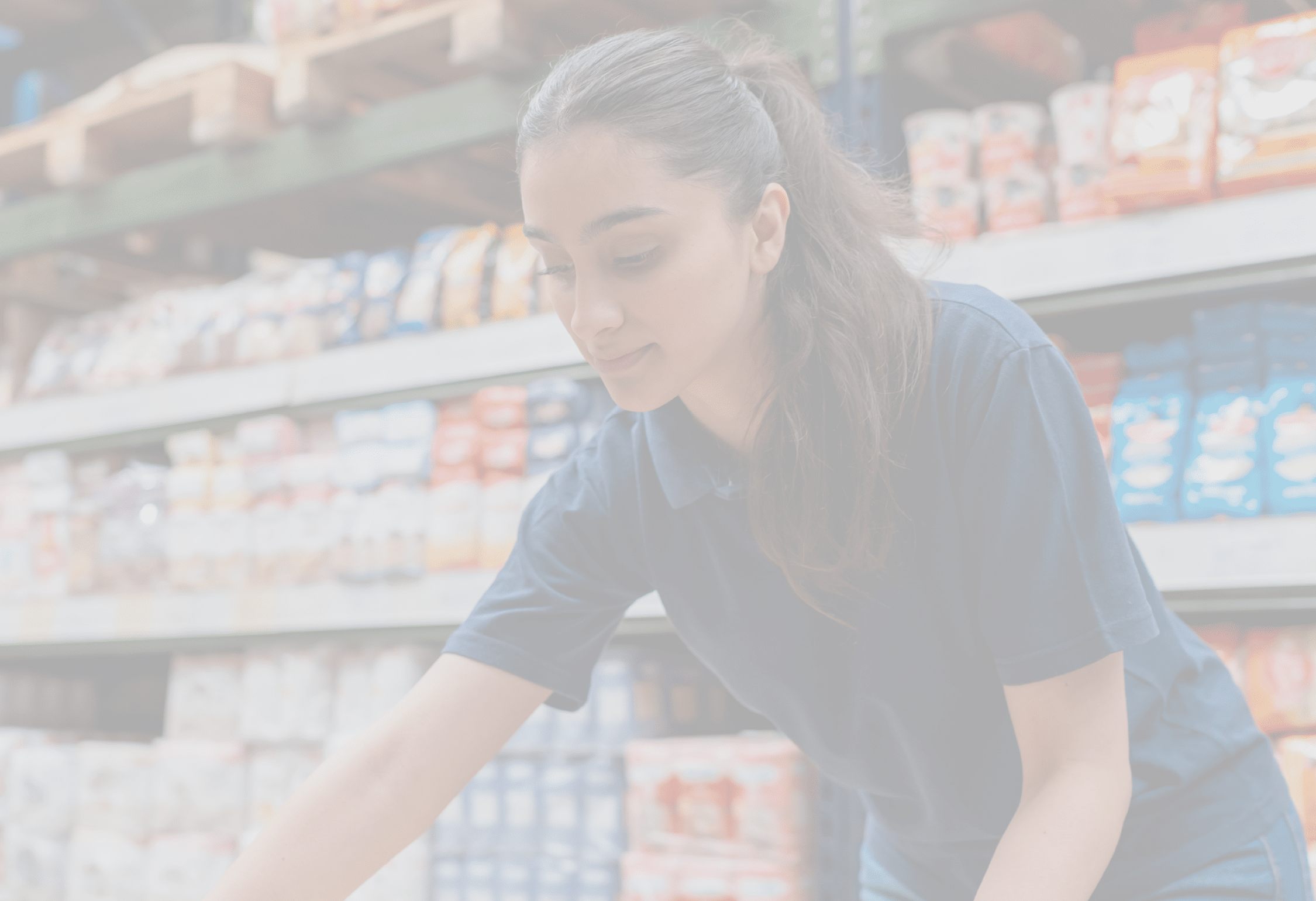 Latin American woman working at the supermarket moving boxes of merchandise